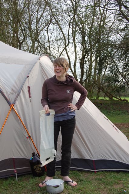 cath beside tent and camping with water bag