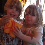 Two children doing cheers with their drinks at Glastonbury Festival