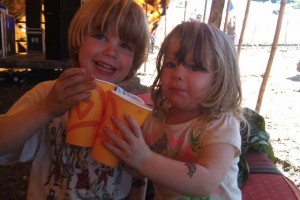 Two children doing cheers with their drinks at Glastonbury Festival